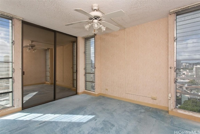 spare room featuring ceiling fan, carpet, and a textured ceiling