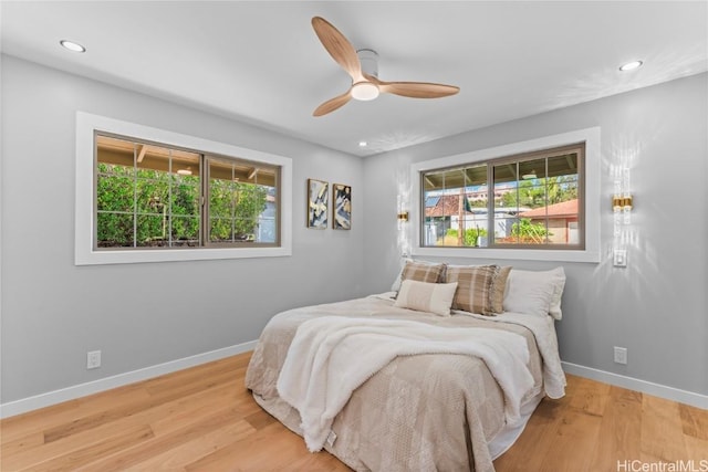 bedroom featuring multiple windows, ceiling fan, and light hardwood / wood-style floors