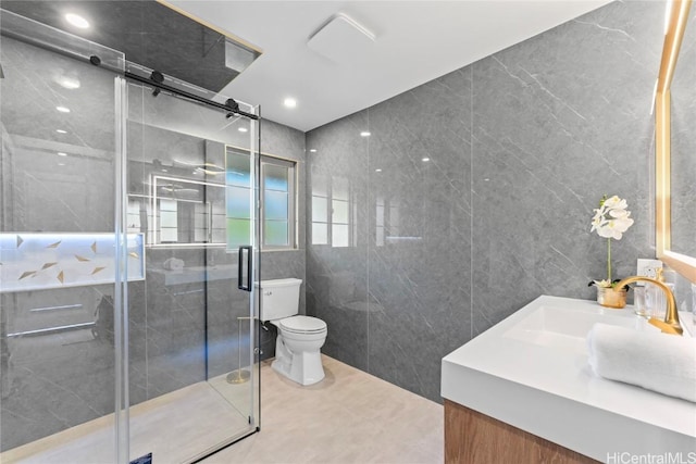 bathroom featuring a shower with shower door, tile walls, tile patterned flooring, vanity, and toilet