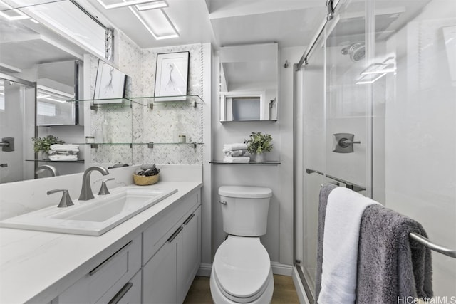 bathroom featuring an enclosed shower, vanity, and toilet