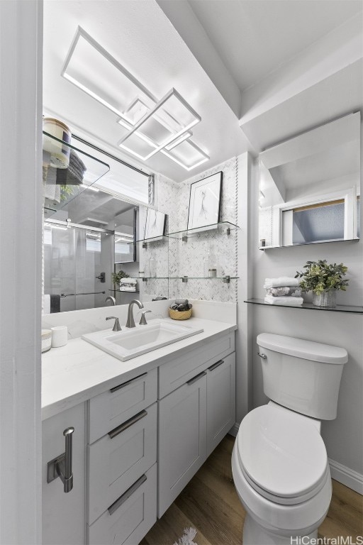 bathroom with vanity, toilet, and hardwood / wood-style floors