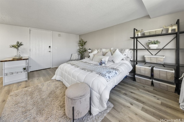 bedroom featuring hardwood / wood-style floors and a textured ceiling