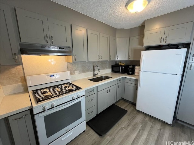 kitchen featuring gray cabinets, sink, and white appliances