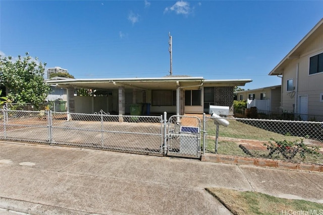 view of front facade featuring a carport, a gate, fence, and driveway