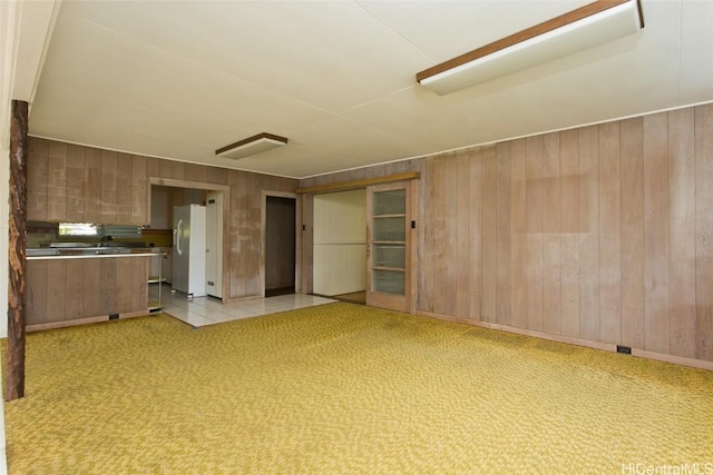 interior space with light carpet and wooden walls