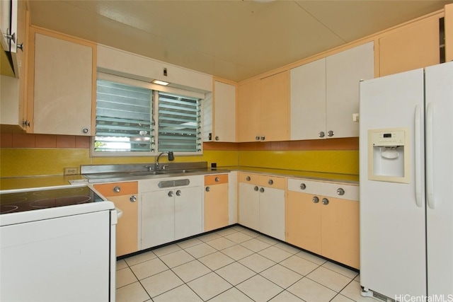 kitchen with a sink, white appliances, and light tile patterned flooring