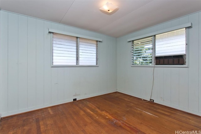 empty room featuring hardwood / wood-style flooring and baseboards