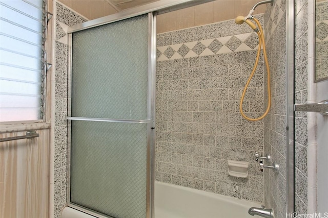 bathroom with bath / shower combo with glass door