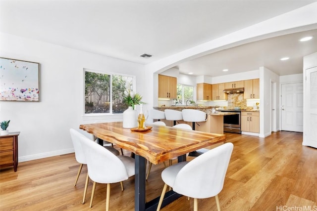 dining area featuring sink and light wood-type flooring