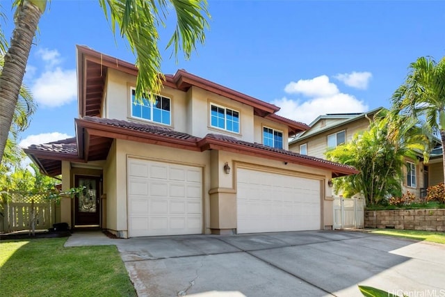 view of front of house with an attached garage, driveway, a tiled roof, and stucco siding