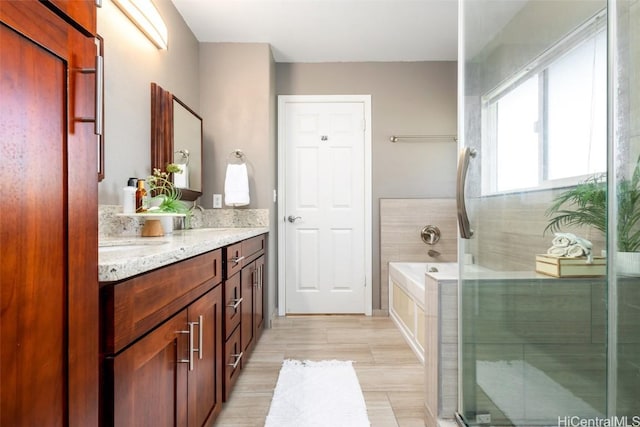 bathroom with hardwood / wood-style flooring, vanity, and separate shower and tub