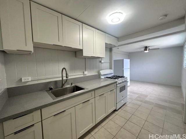 kitchen featuring sink, white appliances, white cabinets, and light tile patterned flooring