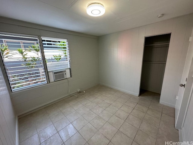 unfurnished bedroom featuring cooling unit and a closet