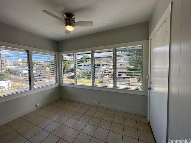 unfurnished sunroom featuring ceiling fan