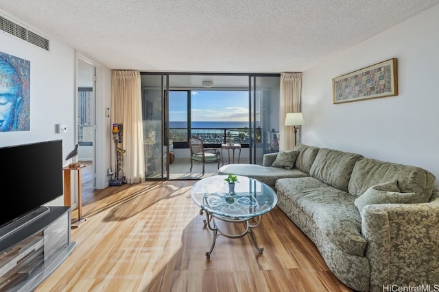 living room featuring hardwood / wood-style floors, expansive windows, and a textured ceiling