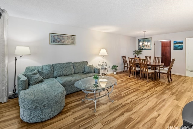 living room with a notable chandelier, hardwood / wood-style flooring, and a textured ceiling