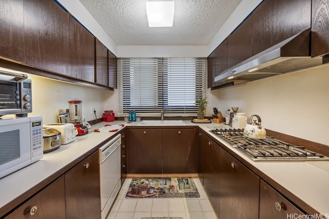 kitchen with sink, extractor fan, dark brown cabinets, a textured ceiling, and white appliances