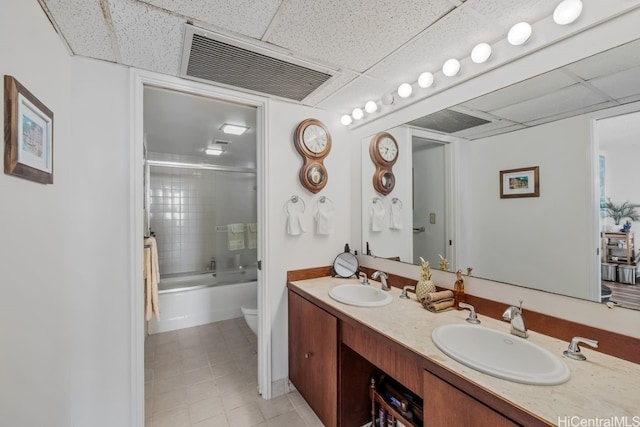 full bathroom featuring vanity, enclosed tub / shower combo, toilet, and a drop ceiling