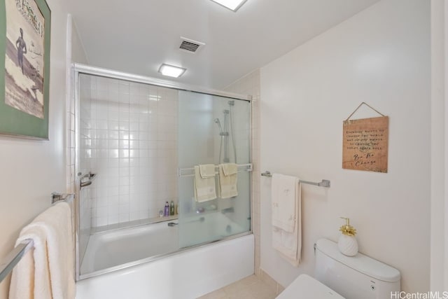 bathroom featuring combined bath / shower with glass door and toilet