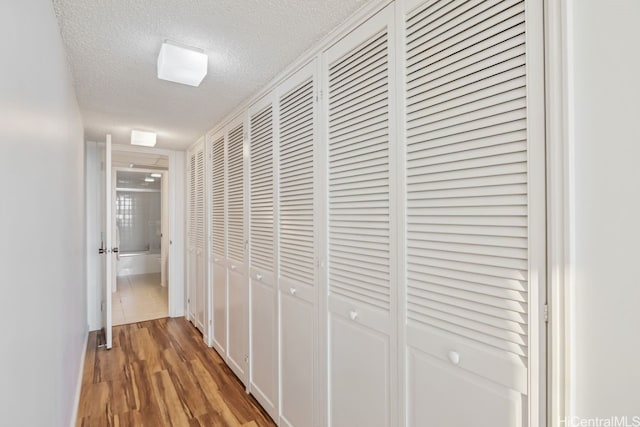 hall featuring hardwood / wood-style floors and a textured ceiling