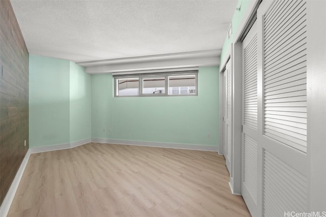 empty room featuring light hardwood / wood-style floors and a textured ceiling