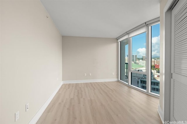 spare room with light hardwood / wood-style flooring and floor to ceiling windows