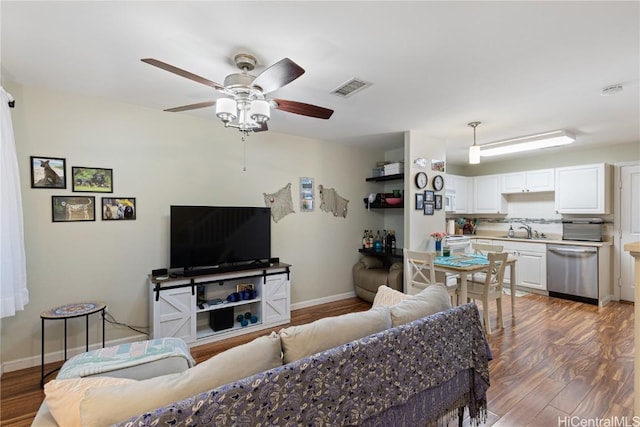 living room with hardwood / wood-style floors, sink, and ceiling fan