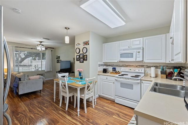 kitchen featuring sink, white cabinetry, hanging light fixtures, hardwood / wood-style flooring, and white appliances