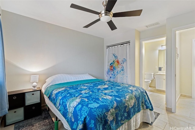 tiled bedroom with ensuite bath and ceiling fan