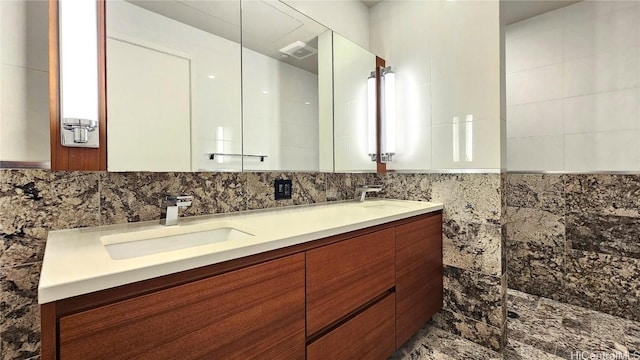 bathroom featuring vanity and tile walls