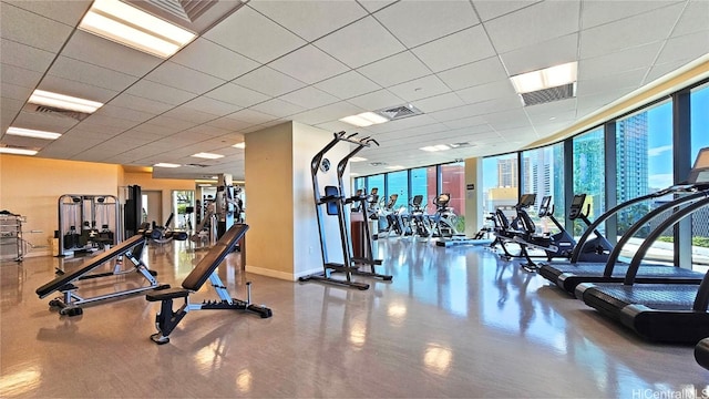 gym with a wall of windows and a paneled ceiling