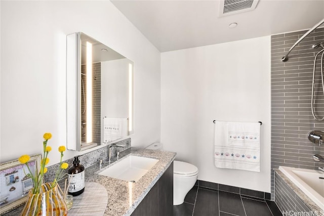 full bathroom featuring vanity, tiled shower / bath combo, tile patterned floors, and toilet