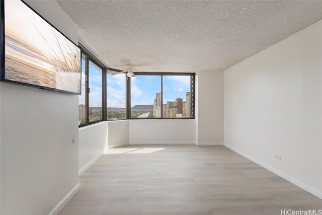 empty room featuring a textured ceiling and light wood-type flooring