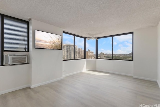 unfurnished room featuring a textured ceiling and light hardwood / wood-style flooring