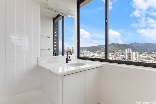 bathroom featuring vanity, a mountain view, and a tub