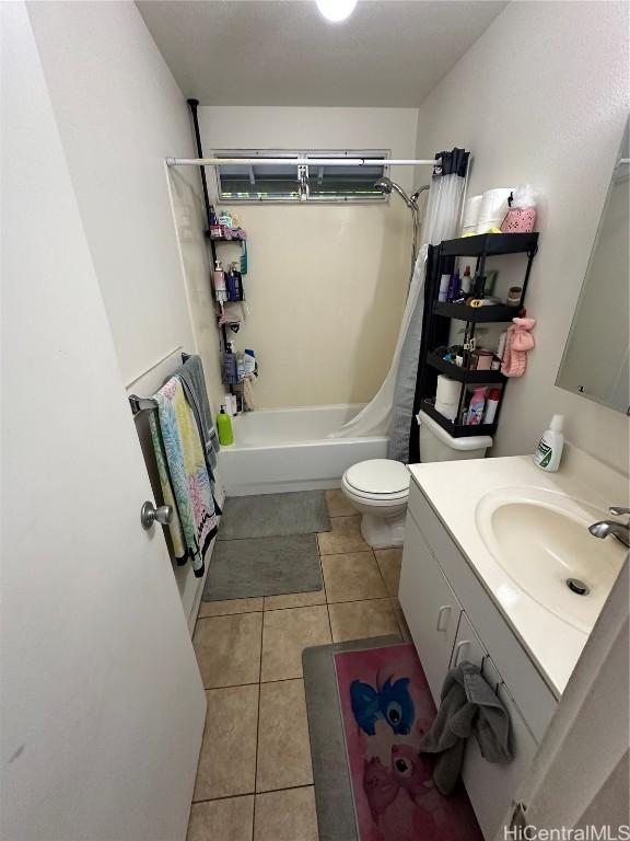 full bathroom featuring tile patterned flooring, vanity, toilet, and shower / bath combo with shower curtain