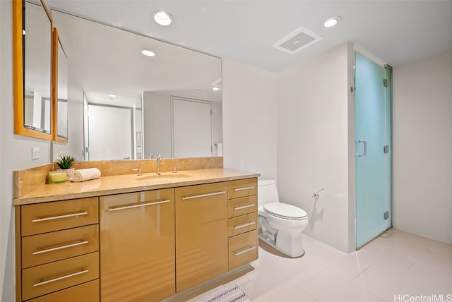 bathroom featuring a shower with door, vanity, and toilet