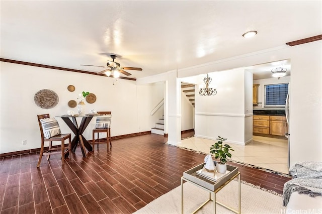 living room with crown molding and ceiling fan with notable chandelier