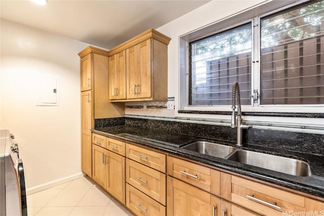 kitchen featuring light tile patterned flooring, electric panel, sink, and dark stone countertops