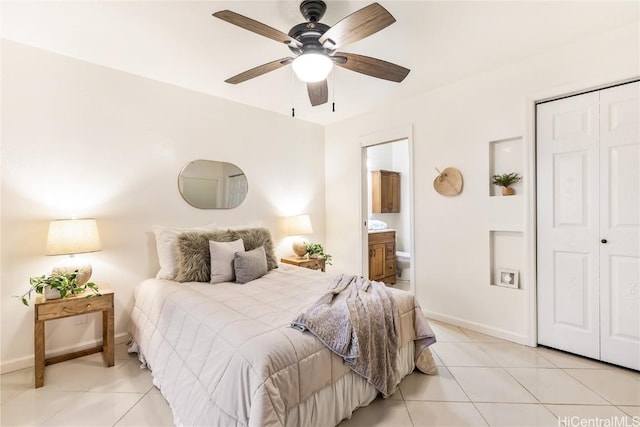 tiled bedroom featuring ensuite bathroom, ceiling fan, and a closet