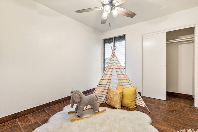 rec room with dark hardwood / wood-style floors and ceiling fan