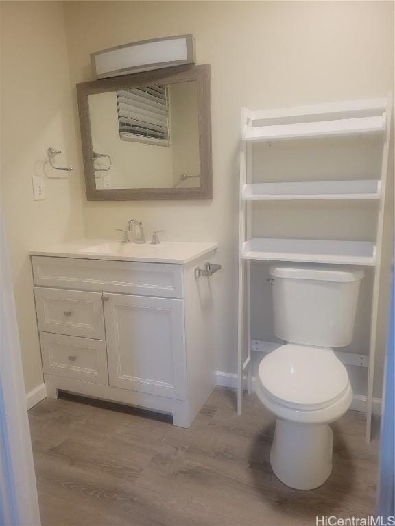 bathroom featuring vanity, hardwood / wood-style flooring, and toilet