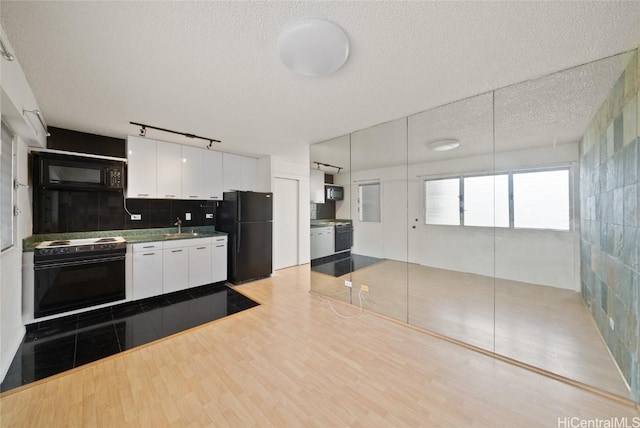 kitchen featuring sink, white cabinetry, black appliances, a textured ceiling, and dark hardwood / wood-style flooring