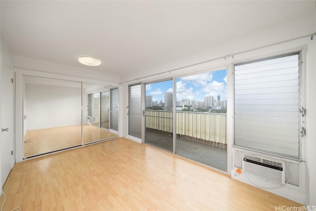 empty room featuring hardwood / wood-style flooring and a wall mounted air conditioner