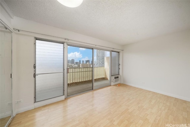 spare room featuring light hardwood / wood-style flooring and a textured ceiling