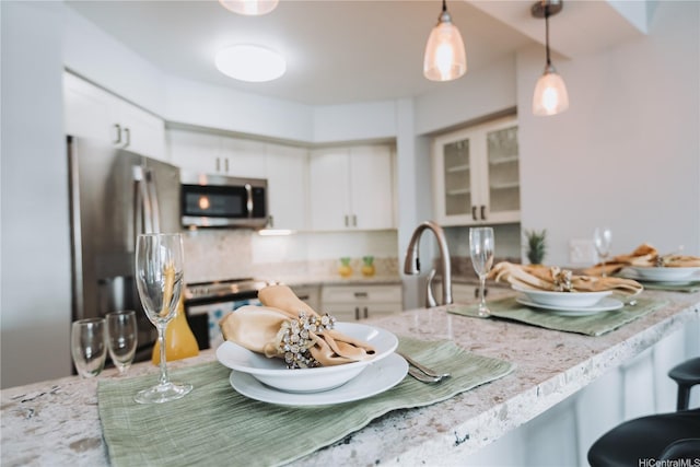 583 Kamoku St Unit 1907, Honolulu, HI 96826 - kitchen featuring stainless steel appliances, backsplash, white cabinetry, decorative light fixtures, and glass insert cabinets