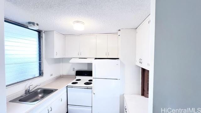 kitchen with sink, a textured ceiling, white cabinets, and white appliances