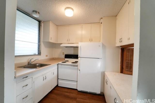 kitchen with dark wood-type flooring, sink, white cabinetry, a textured ceiling, and white appliances