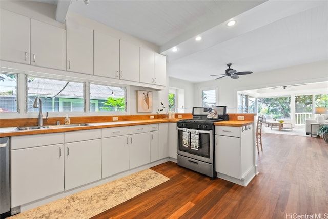 kitchen with sink, appliances with stainless steel finishes, white cabinetry, dark hardwood / wood-style flooring, and kitchen peninsula