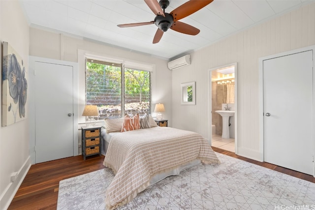 bedroom featuring ensuite bath, wood-type flooring, ornamental molding, ceiling fan, and a wall unit AC